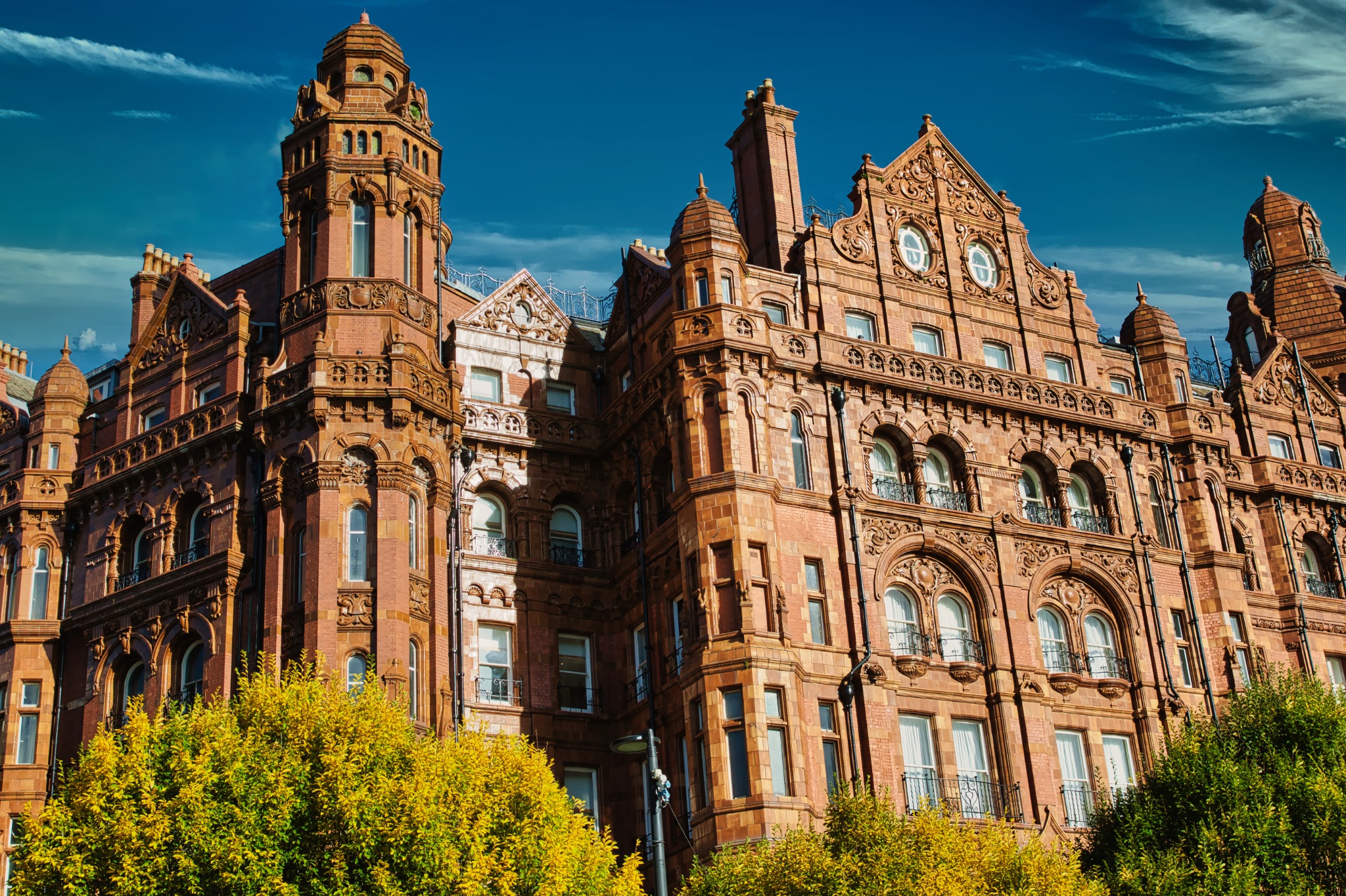 Red Brick Building with Ornate Details and Clock Face in Manchester, UK.